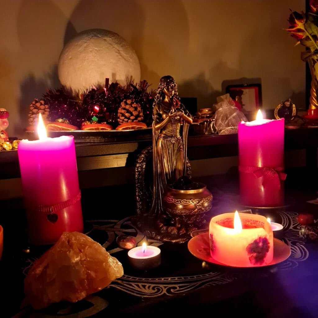 Pink candles, crystals and a goddess figure on Yulia's altar