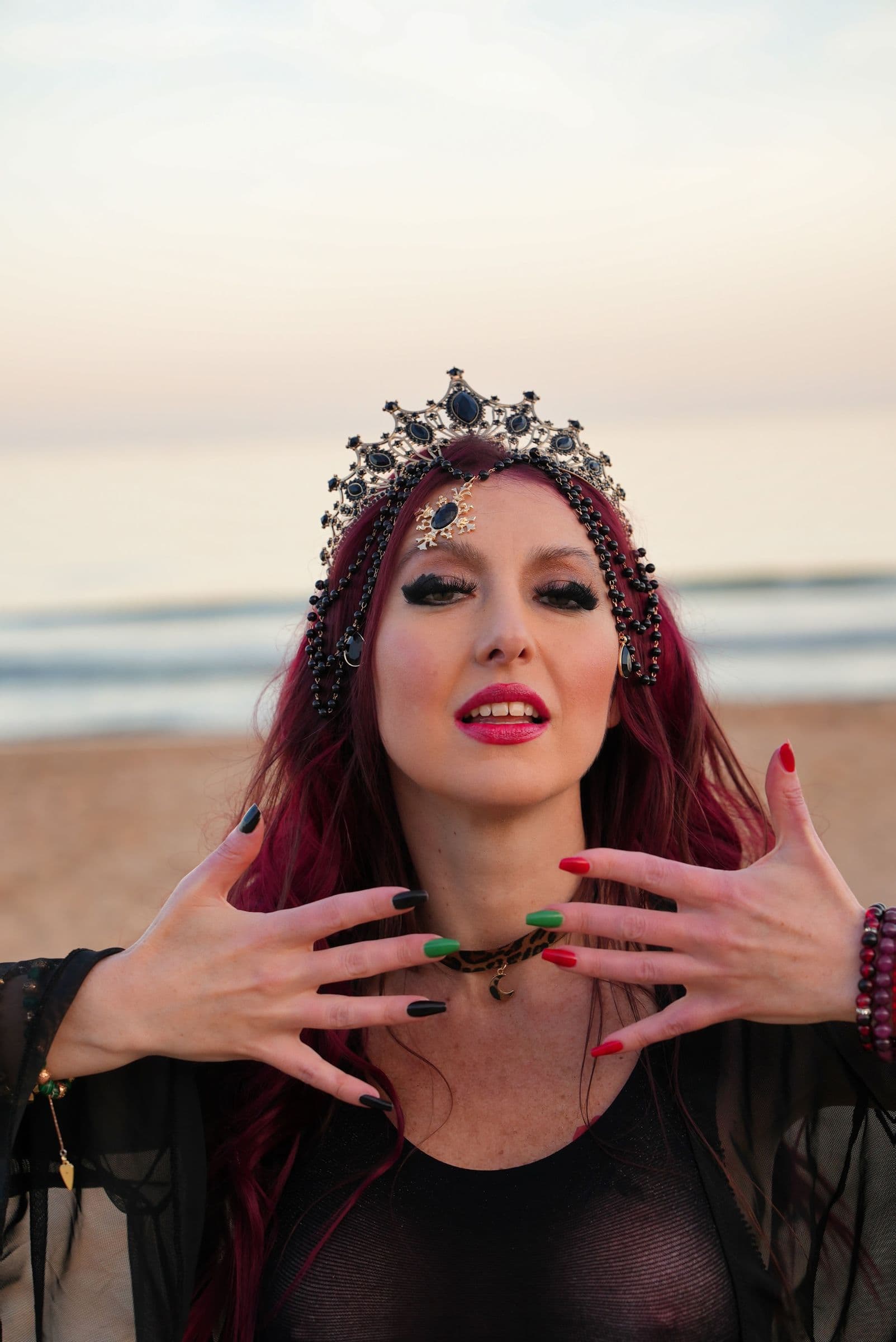 Yulia in a jewelled crown at dusk, hands framing her face