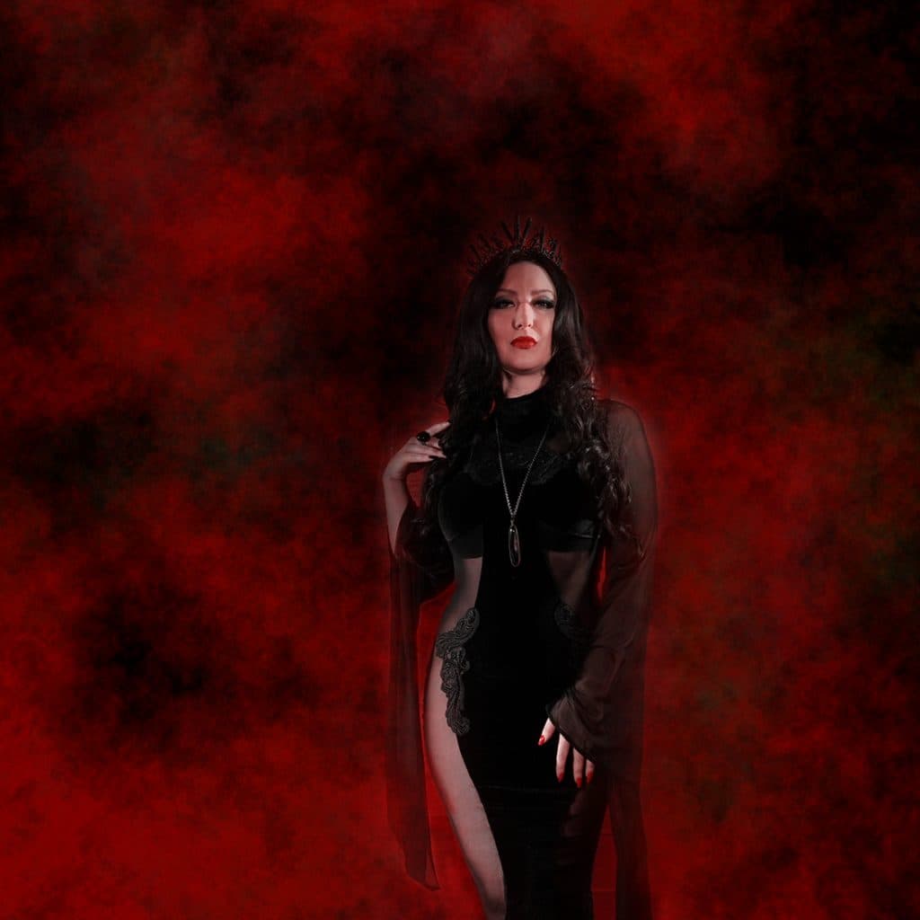 Yulia in a long black dress against swirling red smoke